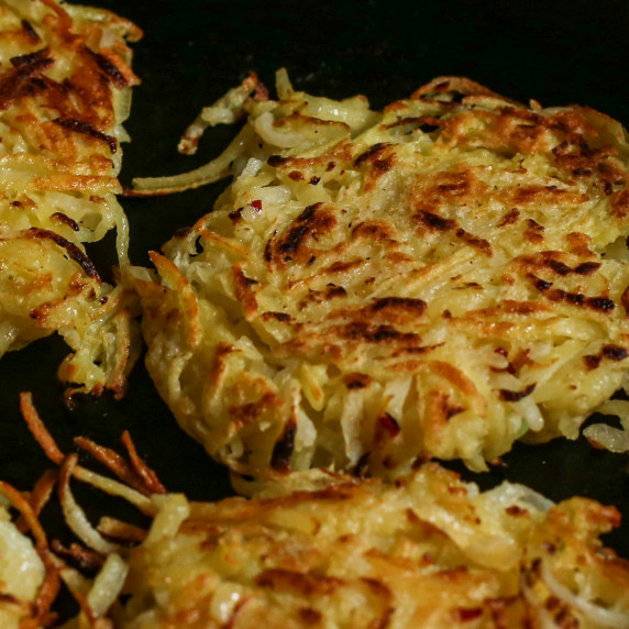 Crispy kohlrabi hash browns closeup in a cast iron pan