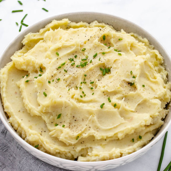 Mashed potatoes in a bowl with pepper and chives.