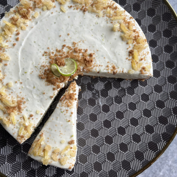a partially sliced no bake key lime cheesecake on a geometric platter