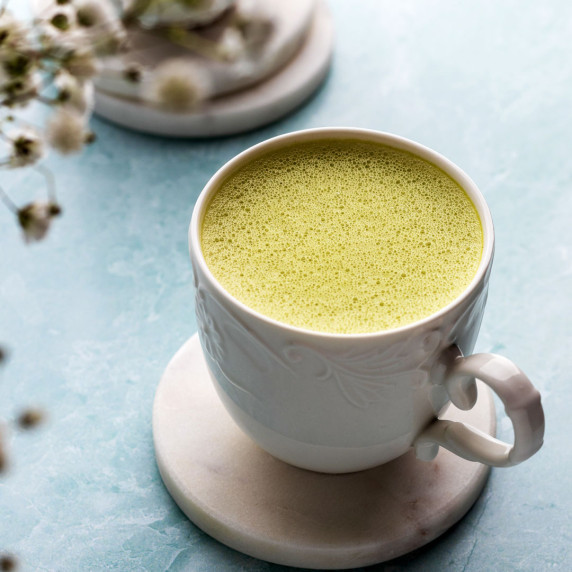 Oat milk matcha latte in a mug on a coaster