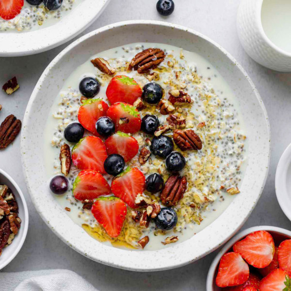 Overnight oats without yogurt served in a white bowl and topped with fresh berries and almonds.