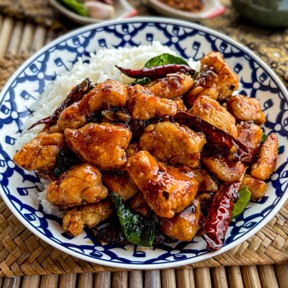Spicy Thai stir-fry with crispy chicken and dried chilies in a blue-white dish.