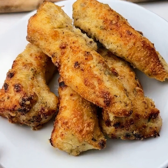 A platter of golden-brown, crispy Parmesan crusted chicken tenders, fresh from the air fryer.