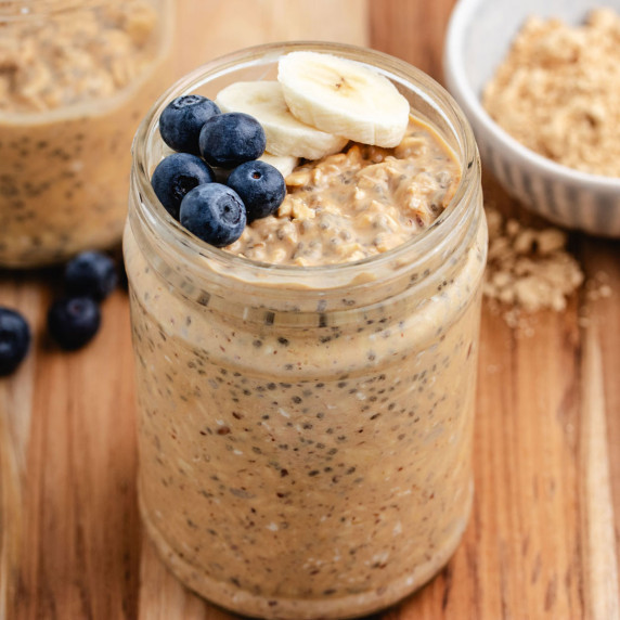 Overnight oats with PB2 in a jar with fresh blueberries and sliced bananas.