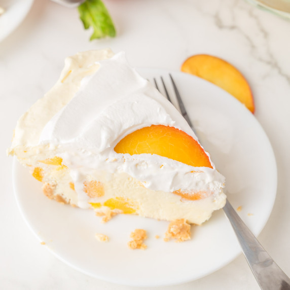 Slice of no-bake peach jello pie on white plate