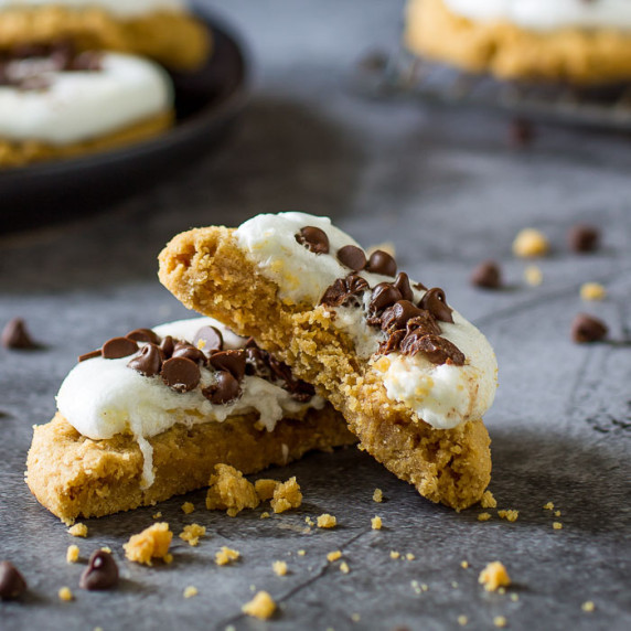 Close up shot of the inside of a smores cookie with more cookies on black plate in the background wi