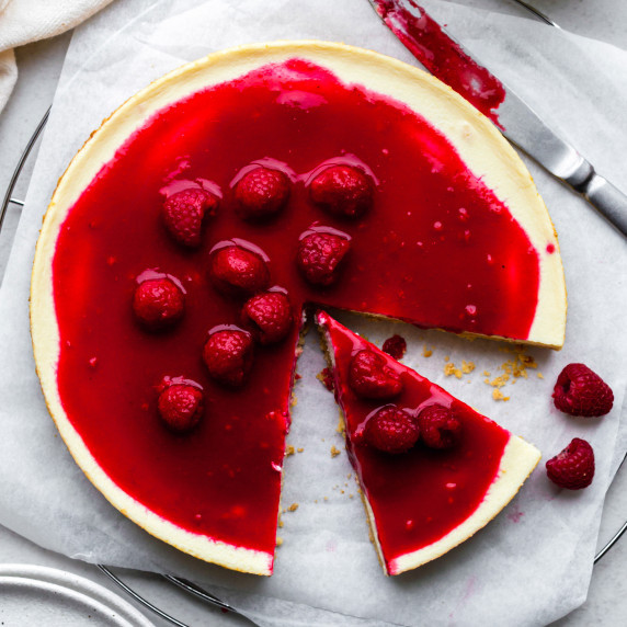 Cheesecake without cream cheese with a slice cut off from it served on parchment paper. Topped with 