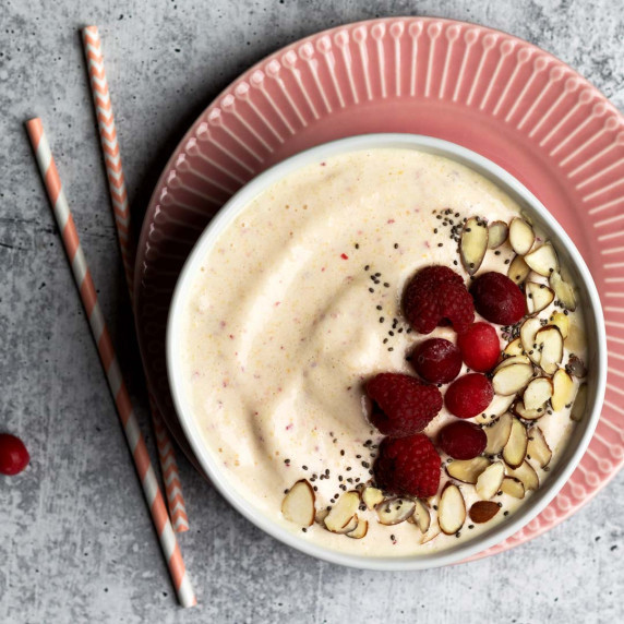 Pineapple peach smoothie bowl with fruit topping shot overhead