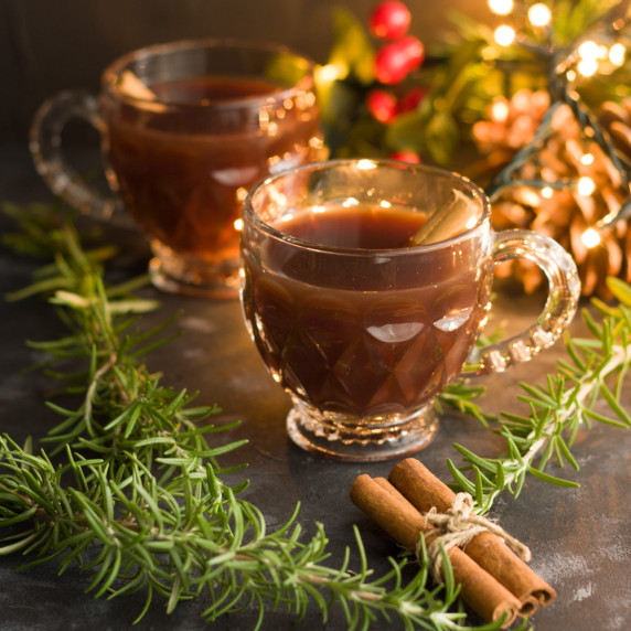 2 cups warm pomegrante and apple mocktail with cinnamon sticks and rosemary