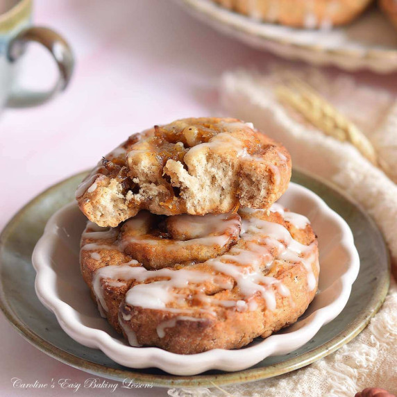 Extra ckise image of 2 buns on top of each other, one half-eaten, filled with pumpkin spice.