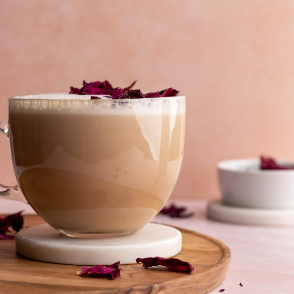 Rose Chai Latte in a glass mug on a coaster