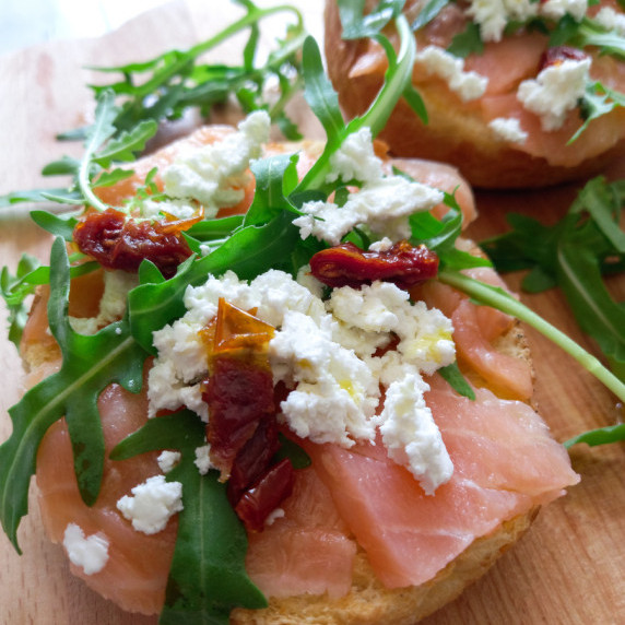 Bruschetta with smoked salmon, feta cheese and fresh arugula.
