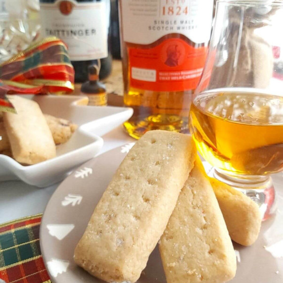 Close shot of 2 Scottish shortbread fingers, with whisky to the background.