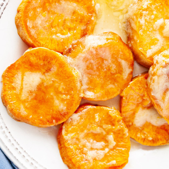 Slices of baked sweet potatoes covered with melted butter. 