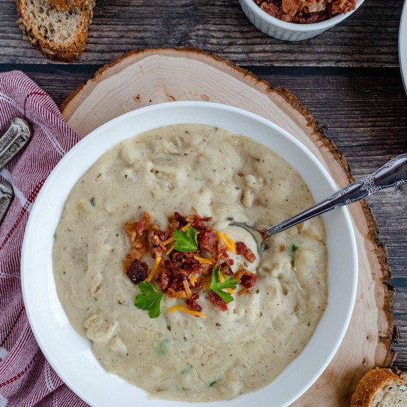 Potato soup with bacon bits and cheddar cheese with a spoon 