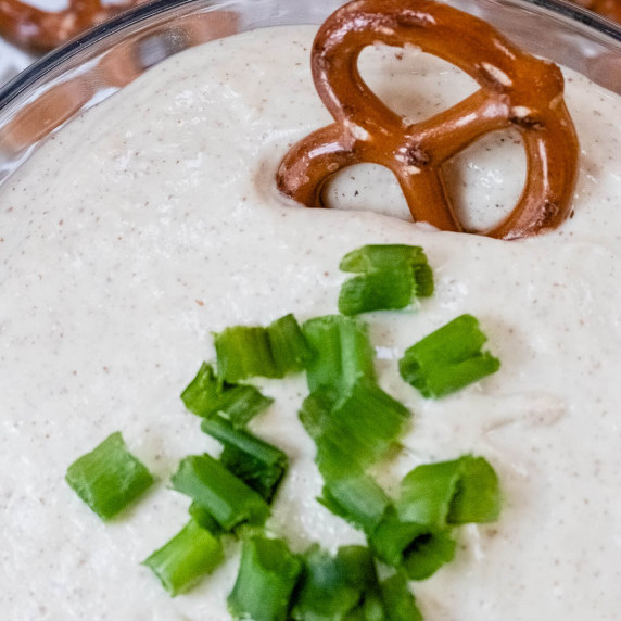 pretzel in white dijon dip topped with chives