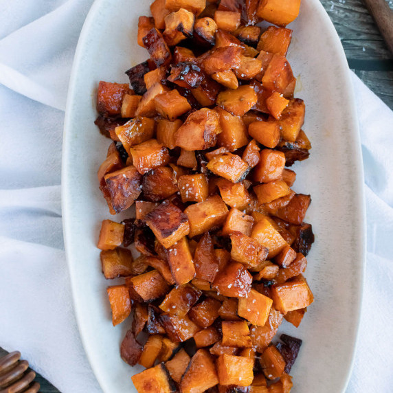Cubed sweet potatoes in a white oval serving dish