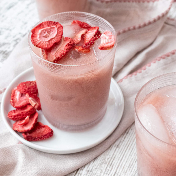 pink drink on white table with strawberries