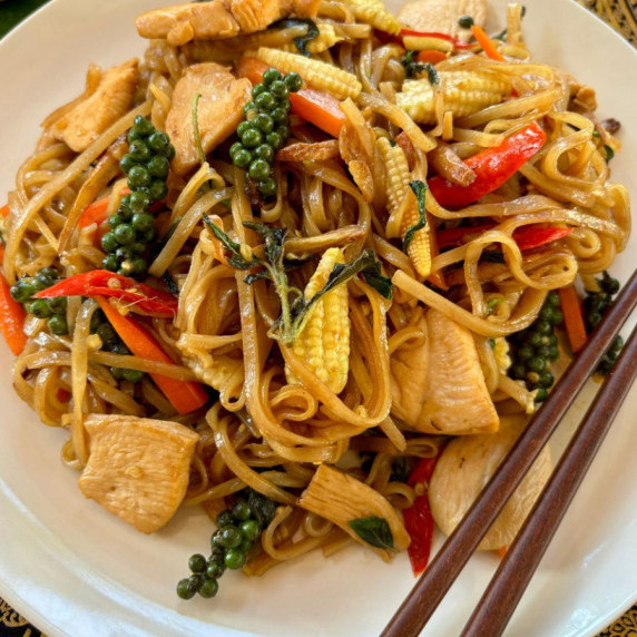 Pad kee mao with vegetables and Thai holy basil served in a white dish