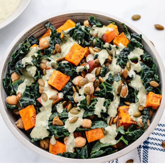 Chickpea salad with roasted sweet potatoes, kale, pumpkin seeds, and a tahini dressing.