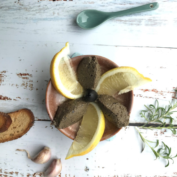 tapenade in a dish with lemon, garlic,bread and rosmarin