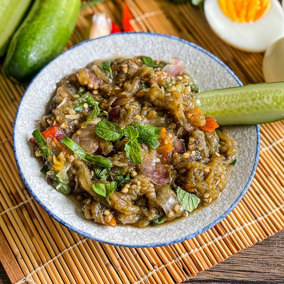 Close-up of Thai roasted eggplant dip with vegetables and fresh herbs.