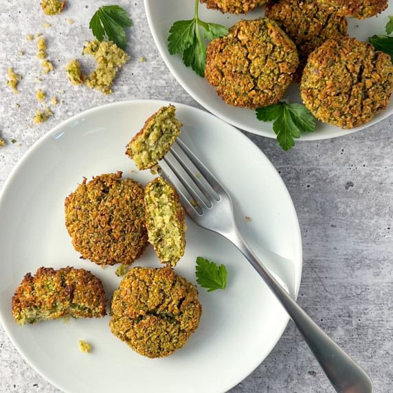 top view of two plates of falafel patties; one with a fork breaking off one of the falafel pieces