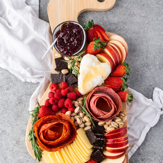 Pops of vibrant red & charcuterie roses make this Valentine's Day charcuterie board perfect for the 