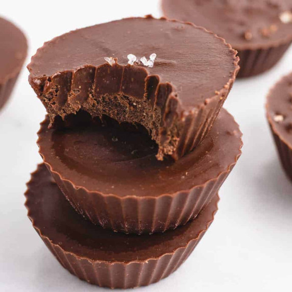 Three chocolate peanut butter fudge cups stacked.