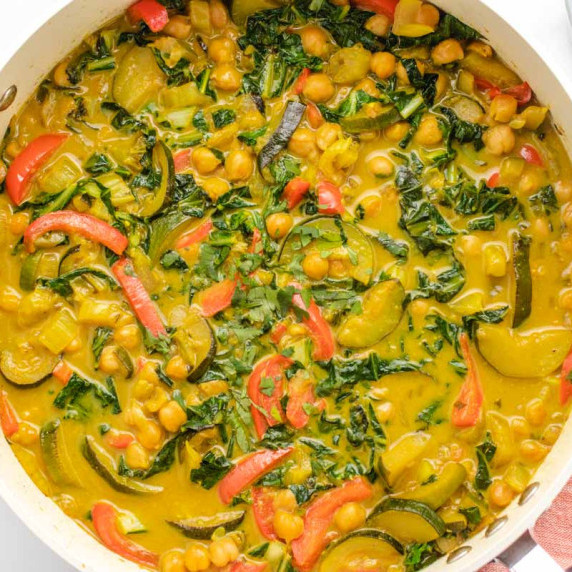 Mixed vegetable curry with coconut milk and brown rice in a bowl.