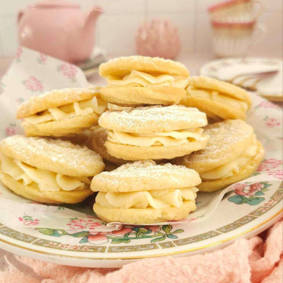 Close front on shot of a pink patterned vintage plate with stack of Viennese Whirl sandwich cookies