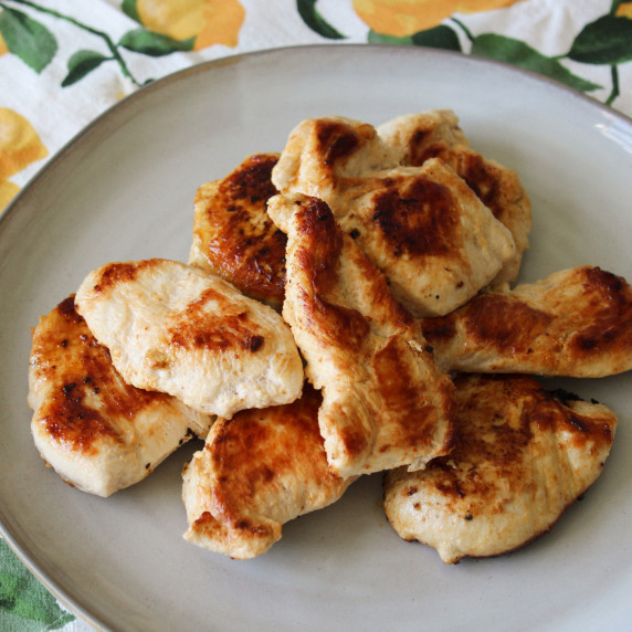 A plate of grilled chicken made with a zesty lemon marinade